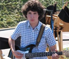 a young man is playing an electric guitar