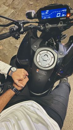 a man sitting on top of a motorcycle next to a speedometer and wrist watch