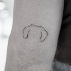 a black and white photo of a person's arm with a dog head tattoo on it