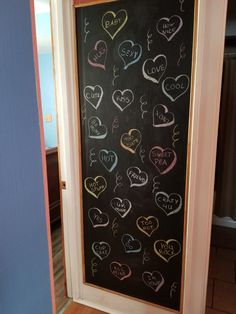 a chalkboard with hearts drawn on it in front of a door that is open