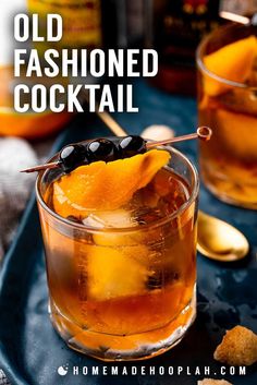 an old fashioned cocktail is garnished with orange peels and black olives