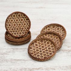 four woven coasters sitting on top of a white wooden table next to each other