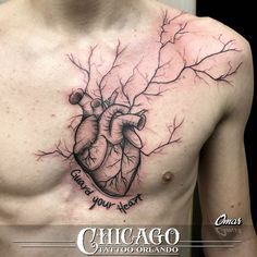 a man's chest with a heart and tree branches tattoo on his chest is shown