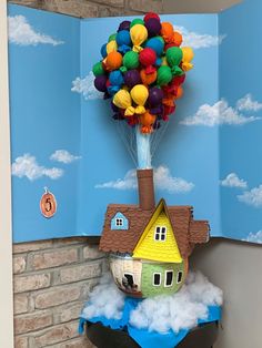 there is a paper house with balloons in the air on top of it and clouds below