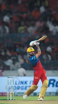 a man in red and blue uniform swinging a bat