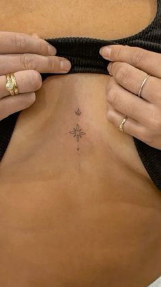 a woman is showing off her small tattoo on her stomach and the bottom part of her body