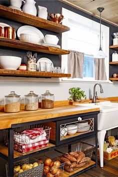 a kitchen filled with lots of open shelves next to a white sink and wooden counter top