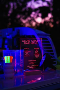 a neon bar menu sitting on top of a table