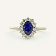 a tan gold ring with a blue sapphire surrounded by white and yellow diamond halos