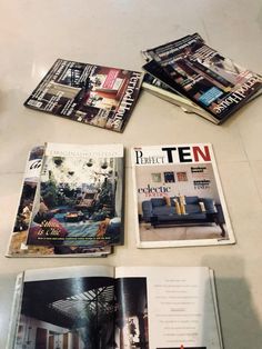 four magazines laying on top of each other next to a table with chairs and couches