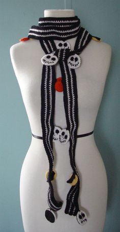 a white mannequin wearing a black and white scarf with skulls on the sides