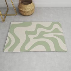 a green and white rug on the floor next to a basket