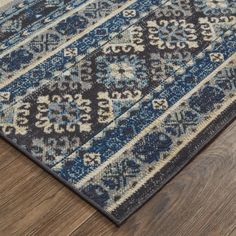 a blue and beige rug on top of a wooden floor next to a wood floor