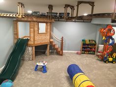 a play room with toys and slides for children to play on the carpeted floor