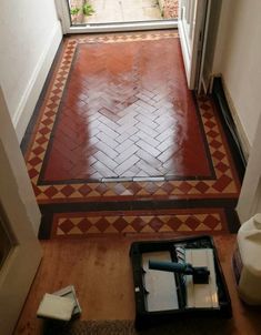 an open door leading to a hallway with red and white floor tiles on the ground