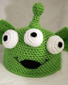 a green crocheted hat with eyes and ears