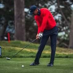 a man in red shirt and blue pants playing golf