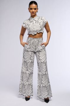 The AKIRA Label Set You Free Palazzo Pant is a structured cotton bottom featuring a high rise design with a shirred elastic waistband, on-seam side slant pockets, light polyester inner lining, circular cut out detailing, and intricate contrast stitching, embroidered to culminate into a layered, abstract pattern. Complete with a wide leg silhouette, decorative scalloped trim, and a pull-on fit. Style with the coordinating AKIRA Label Set You Free Crop Woven Top for a finished look.   - Main: 100% Cotton, Lining: 97% Polyester 3% Spandex - Non-Stretch Fabric; Stretchy Waistband - Imported  (all measurements are approximate from size small) - 12” Rise - 33” Inseam - Model is 5’9” Product ID: 399488  (all measurements are approximate from size 1X) - 13.5” Rise - 33.75” Inseam  Product ID: 3994 Conservative Outfits, Free Crop, Palazzo Pant, Cotton Bottoms, Set You Free, Woven Top, Palazzo Pants, Abstract Pattern, Fashion Prints