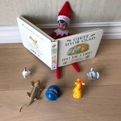 an elf is reading a book to his pet lizards and other toys on the floor