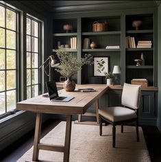 a home office with green walls and built - in bookshelves is pictured here