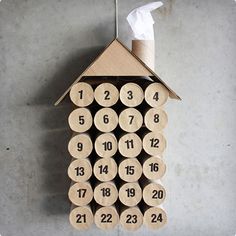 a house shaped clock made out of cardboard with numbers on the front and back side