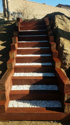 a set of steps made out of wood with gravel on the bottom and sides in between them