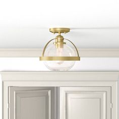 a light fixture hanging from the ceiling in a room with white walls and cupboards