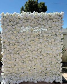 a large white flower wall with the words better together written in cursive writing