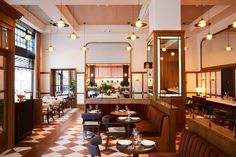 an empty restaurant with checkered flooring and high ceilings is seen in this image