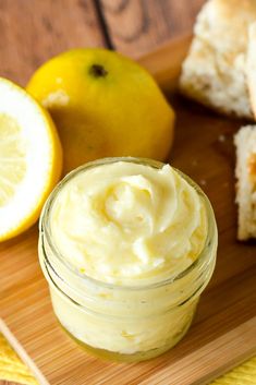 a jar of mayonnaise next to sliced lemons on a wooden cutting board