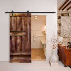 a living room with a couch, chair and sliding door that has wood slats on it