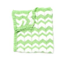 the green and white blanket is folded up