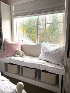 a window seat with storage baskets underneath it