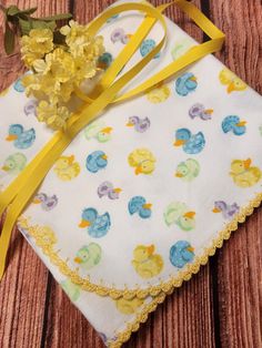 a yellow flower is sitting on top of a white cloth with blue and yellow ducks