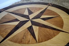 a wooden table with a star design on the top and wood grain inlays