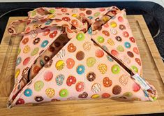 an oven mitt covered in doughnuts on top of a wooden cutting board