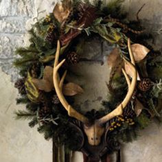 a deer's head with antlers and pine cones is mounted on the wall