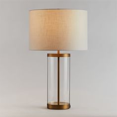 a lamp that is on top of a table with a white shade over the base