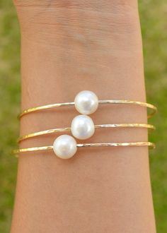 Price is for ONE bangle. Photos may show multiple bangles that are for purchase separately. Classic, chic, white freshwater pearls are always popular! These pearls are smaller than the Edison and Tahitian pearl bangles. Pearls are near round and approximately 9.5-10mm in size. They are not completely flawless and may have small dimples or surface imperfections but overall they look spectacular on a bangle! Wire is 12 gauge and available in your choice of silver or gold filled wire. These are han Pearl Bangles, Pearl Bangle Bracelet, Hawaii Jewelry, Hawaiian Jewelry, Pearl Bangle, Jewelry Pearl, 12 Gauge, Bridesmaid Bracelet, Bridal Bracelet