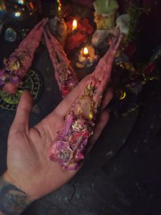 a person's hand covered in flowers next to candles