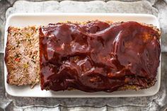 meatloaf on a white plate with sauce drizzled over the top