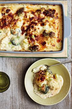 a casserole dish with broccoli, cheese and sauce on the side