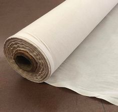 a roll of white fabric sitting on top of a floor