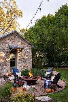 an outdoor fire pit with chairs around it