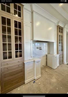 an empty kitchen with white cabinets and marble counter tops in the process of remodeling