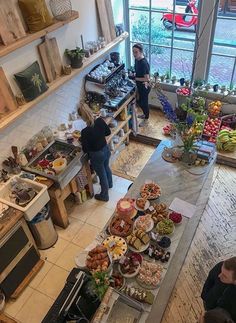 an overhead view of people standing in a kitchen with food on the counter and shelves