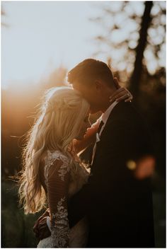 a bride and groom standing close to each other in front of the sun at their wedding