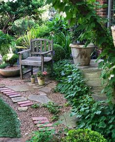 a wooden bench sitting in the middle of a garden