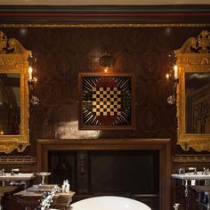 a bath room with two sinks and a large mirror on the wall next to a fireplace