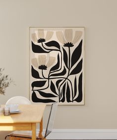 a dining room table with chairs and a painting on the wall above it that has flowers in black and white